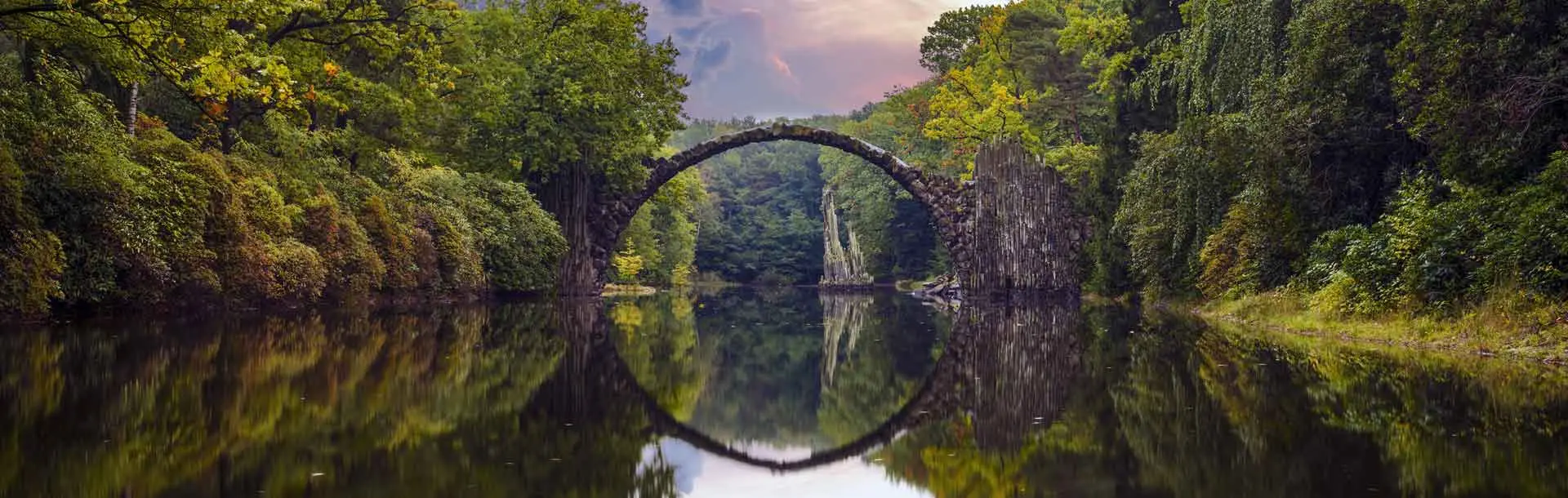 Bild: Ein Fluss mit einer Brücke und ringsherum ist Wald